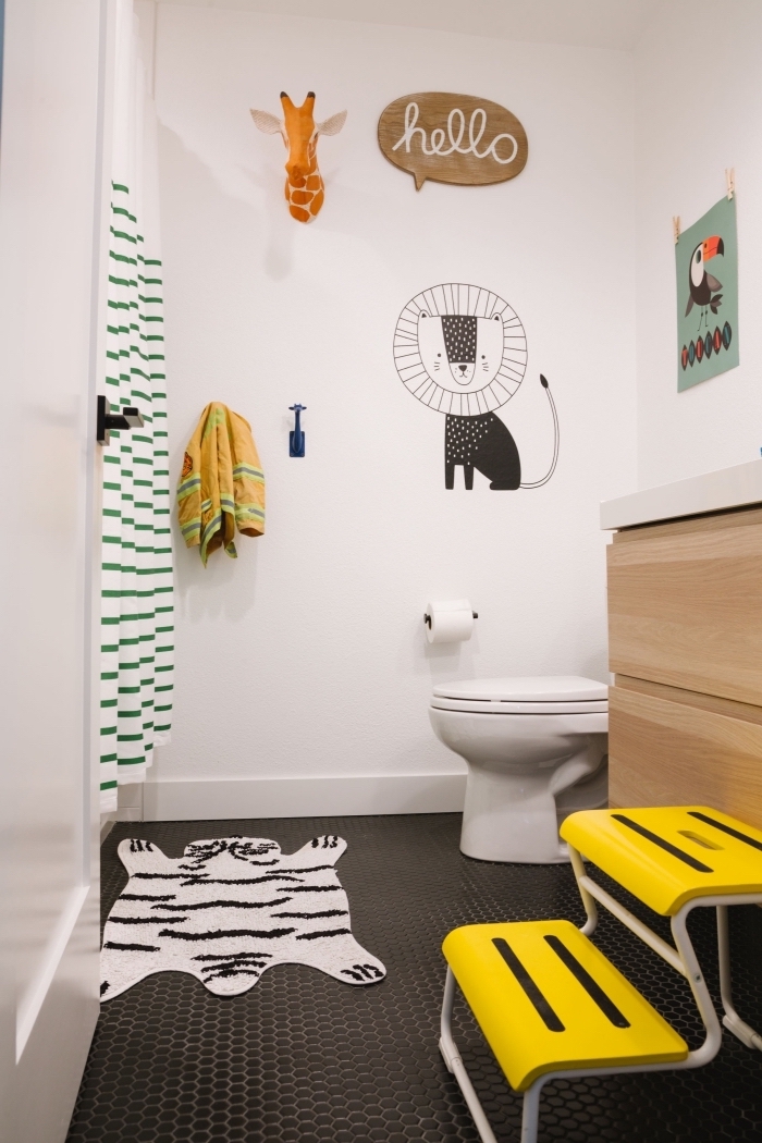 salle de bain blanche et bois avec sol en carrelage noir, décoration petite salle d'eau pour enfant à motifs animaliers