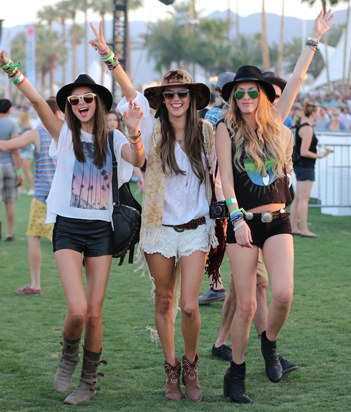 Trois amies habillées bien pour un festival de musique quand il fait chaud, pantalons courts, t-shirt de bande, chapeau et lunettes de soleil, tenue coachella inspiratrice au style bohème pour le desert