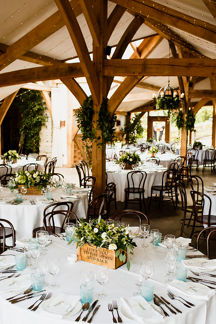 Table ronde rangé simplement de fleurs blanches, verres bleu claires, idée deco mariage champetre, style boheme chic mariage plein nature