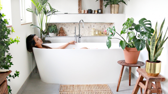 Baignoire ovale dans une salle de bain peinte en blanc avec beaucoup de plantes vertes, quelle couleur pour une salle de bain, déco petite salle de bain