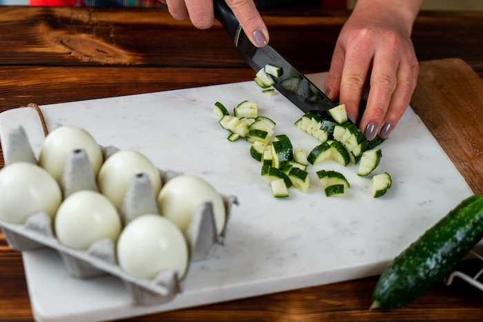 couper une concombre en dés pour faire entree de pques, recette oeuf mimosa simple et rapide