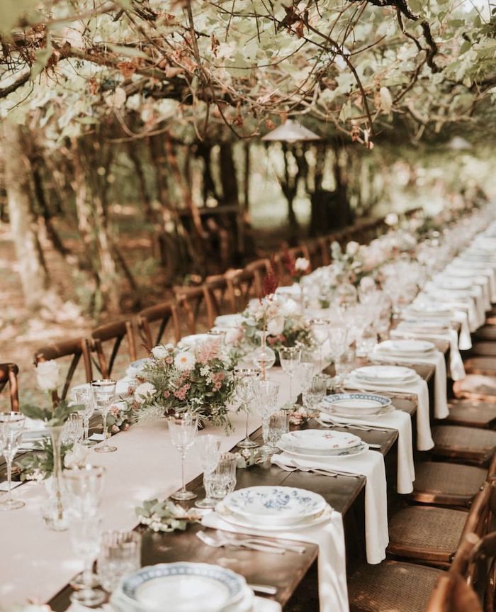 Table longue pour 50 personnes mariage champêtre chic, theme de mariage champetre, assiettes vintage porcelaine chemin de table lin et vases avec fleurs de champs en haut