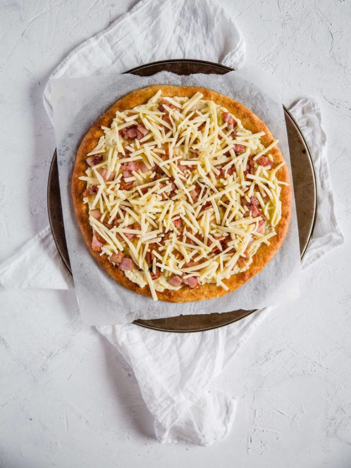 fromage râpé et bacon pour faire une pizza sans gluten sur pâte à pizza sans gluten dans plaque de cuisson
