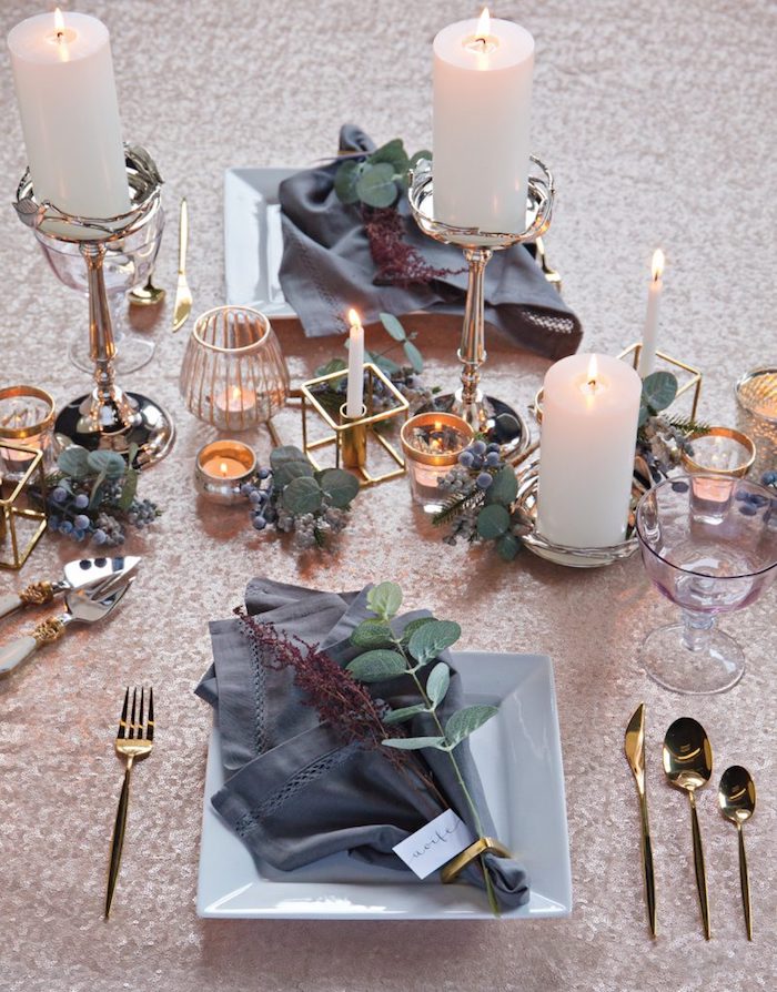 Simple assiette joliment décoré avec plante verte, nappe en lin bleu sombre, bougies et branches mariage champêtre chic, décoration élégant au style rustique