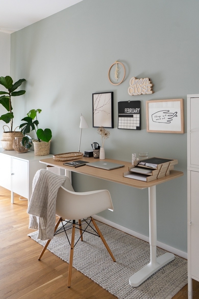 espace de travail dans une pièce aux murs vert menthe avec parquet bois, modèle de bureau blanc et bois pour home office