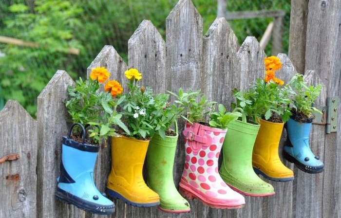 deco a faire soi meme pour le jardin en bottes de caoutchouc recyclées de couleurs variées avec des fleurs plantées