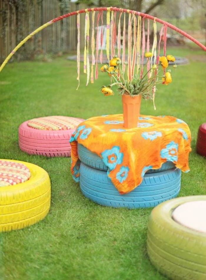 recyclage pneu pour fabriquer un salon de jardin en pneus repeints avec table et tabourets en pneus en plein air