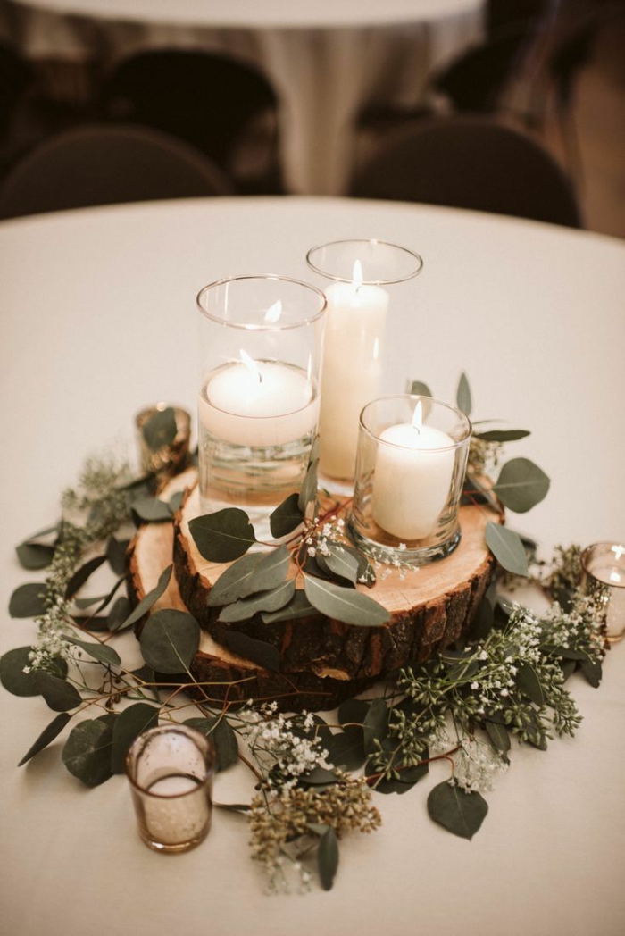 Bougies allumées décorés de feuilles vertes sur plancher ronde bois piece centrale. idee decoration mariage, decoration table mariage champetre chic