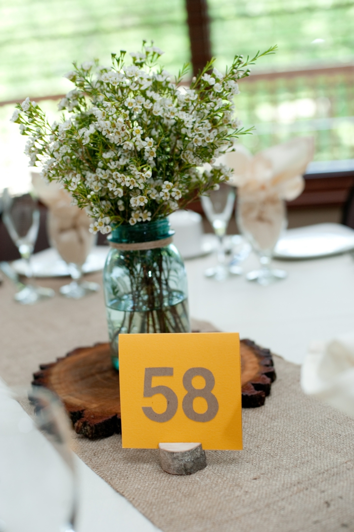 Bocal en verre plein de fleurs champetres, marque table bois mariage theme champetre, decoration table mariage champetre simple