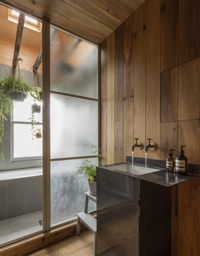 conception moderne dans une salle de bain bois et blanc avec évier noir, idée déco salle de bain zen avec plantes suspendues