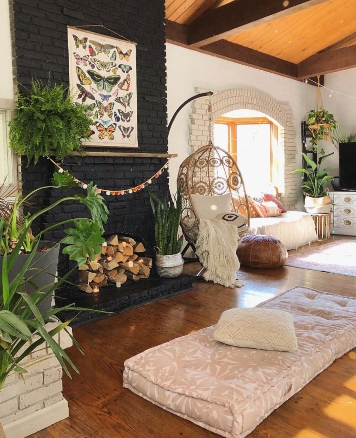 design salon en rotin avec pan de mur en briques noires et parquet bois, décoration pièce de style bohème chic avec plantes