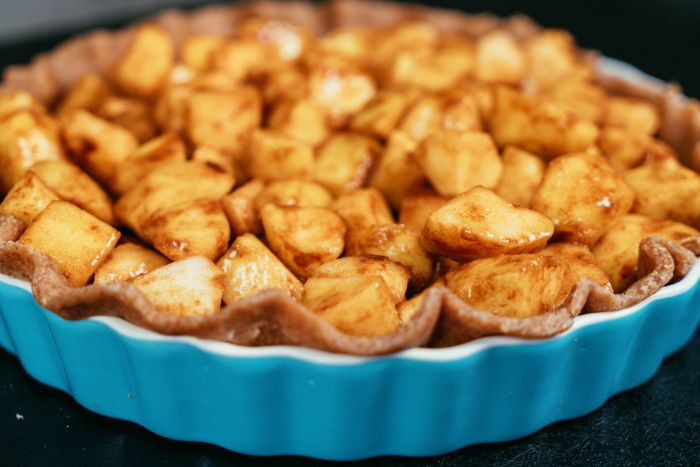 verser les cubes de pommes à la cannelle dans la plaque à tarte, idée dessert aux pommes americain, tarte aux pommes maison