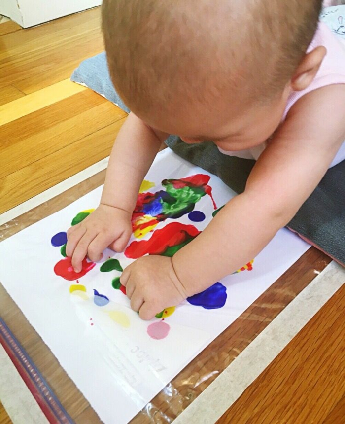 Aider son bébé à faire sa premiere peinture coloré, cool idée cadeau fete des peres original, bricolage fête des pères pour tout petit