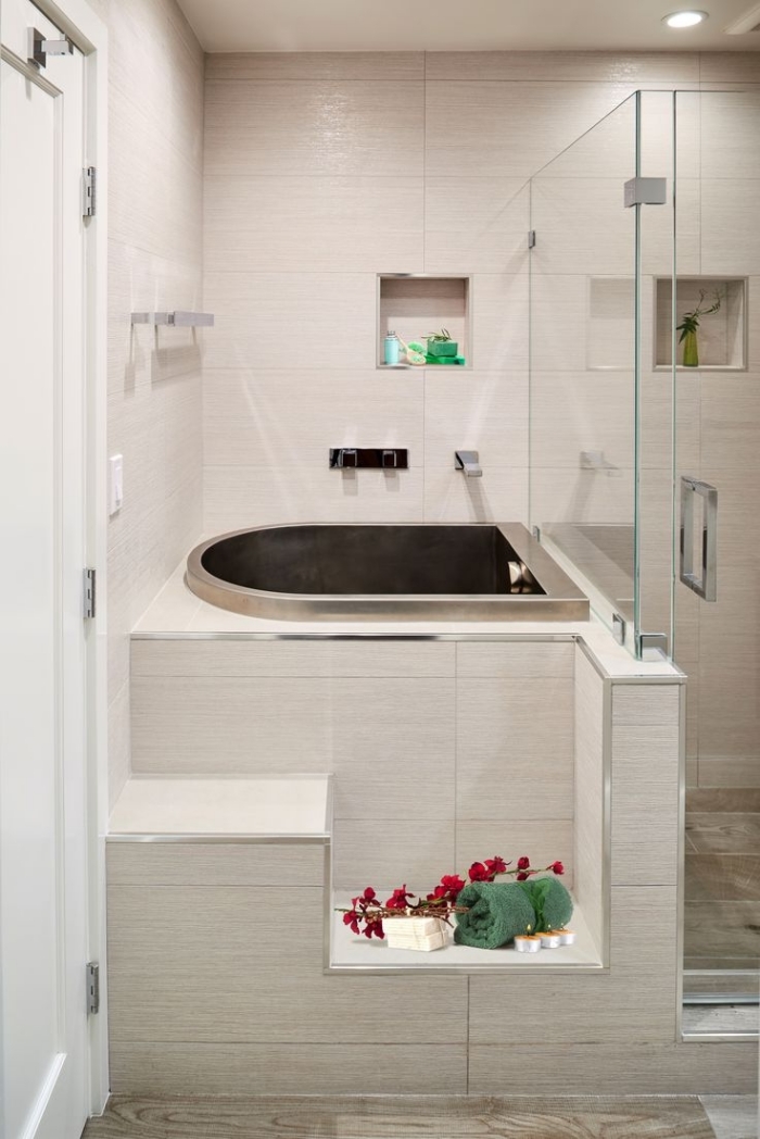 modèle de petite baignoire dans une petite salle de bain décorée en couleurs neutres et accents aspect pierre naturelle