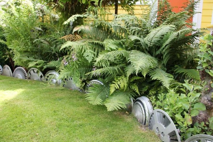 jante de roue de voiture recyclée pour créer une bordure pelouse originale avec matériaux recyclés
