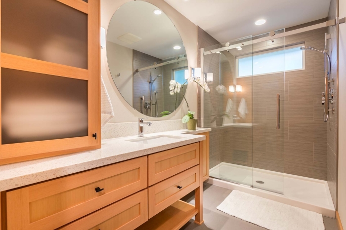 design salle de bain bois et blanc avec cabine de douche, décoration petite salle de bain avec grand miroir rond et fleurs