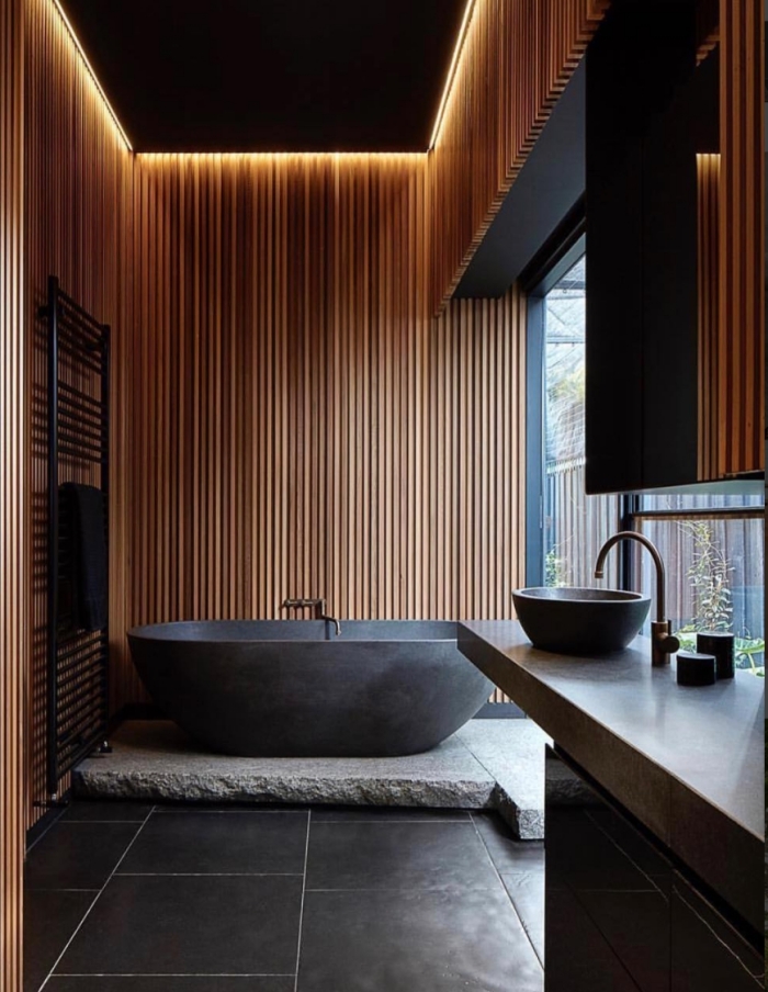idée déco salle de bain relax, design salle de bain aux murs en bois avec sol en gris anthracite, modèle de baignoire gris foncé