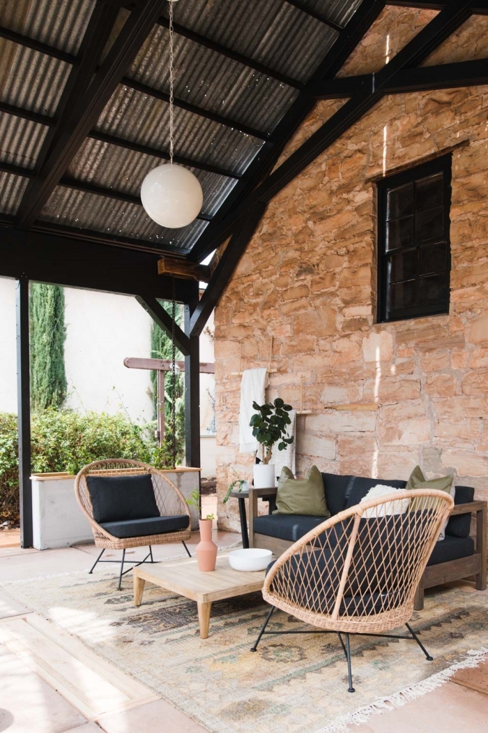 déco bohème pour terrasse ou cour arrière avec meubles confort en rotin et pieds métal, décor extérieur en bois et noir