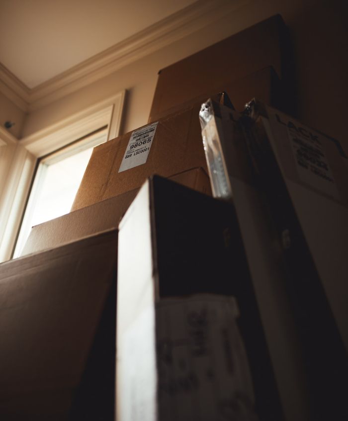 pile de cartons de déménagement dans une chambre, déménagement particulier formalités et démarches