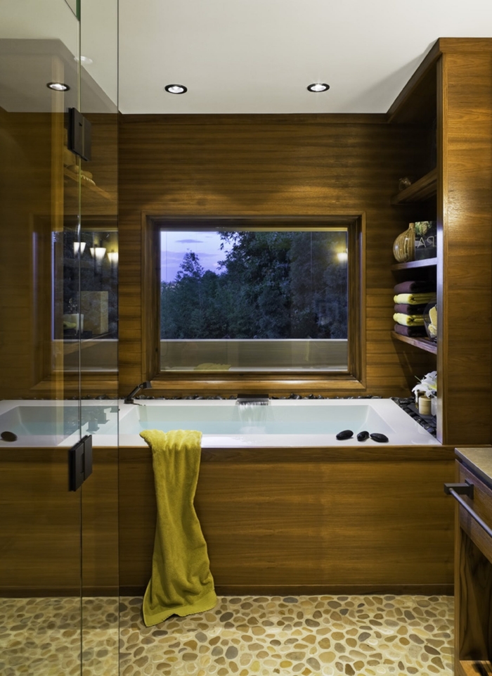 aménagement petite salle de bain avec baignoire, design salle de bain aux murs en bois avec sol en cailloux et accents métal