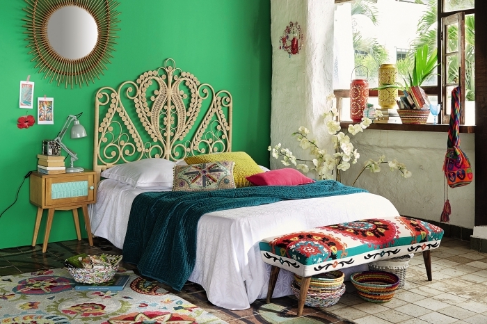 déco chambre nature aux murs verts avec revêtement de sol en carrelage beige et meubles en fibre végétale, banquette multicolore avec pieds bois