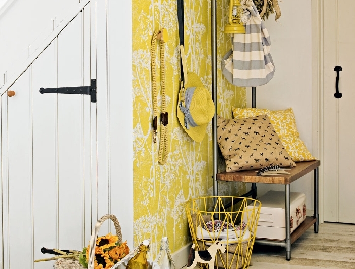 aménager une entrée de couleur jaune papier peint jaune à motifs fleurs blanches banquette bois et métal tapis jupe panier tressé blanc