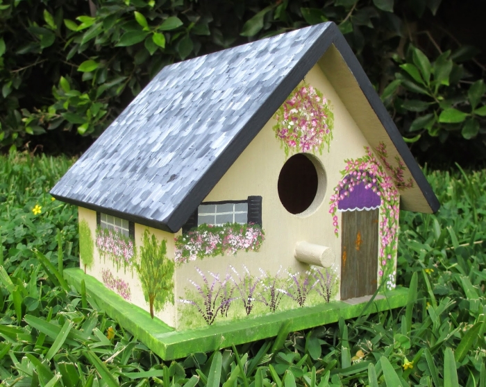 modèle de petite cabane à oiseaux décorée avec peintures sous forme de fenêtre et portes avec véranda en peinture verte