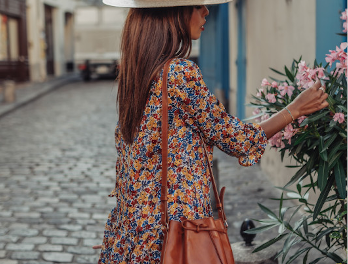 des idées pour vos tenues de vacances printemps ete sac a main poche debardeur robe champetre inspiration robe fleurie pour femme élégante qui s arrete pour sentir les fleurs