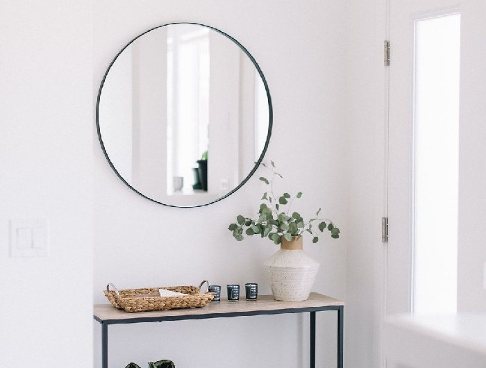 déco entrée maison style minimaliste intérieur déco scandinave couloir blanc meubles métal noirci panier tressé tapis franges miroir rond