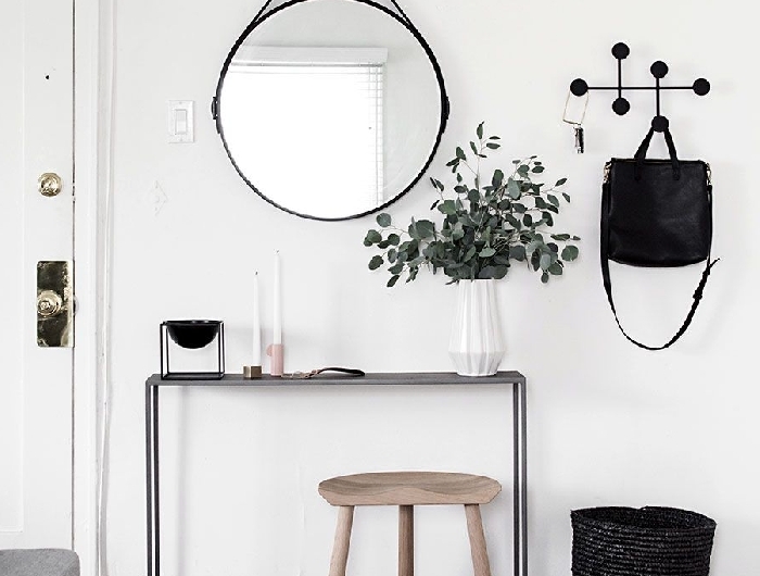 décoration entrée appartement design scandinave style minimaliste miroir rond noir vase origami blanc tabouret bois clair panier tressé beige et noir