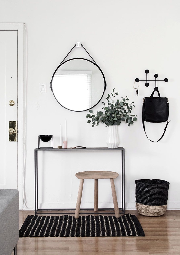 décoration entrée appartement design scandinave style minimaliste miroir rond noir vase origami blanc tabouret bois clair panier tressé beige et noir