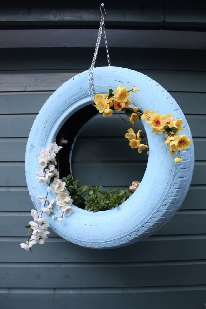 idée de décoration extérieure facile à faire avec objet recyclé, modèle de jardinière en pneu peint en blanc avec chaîne métal