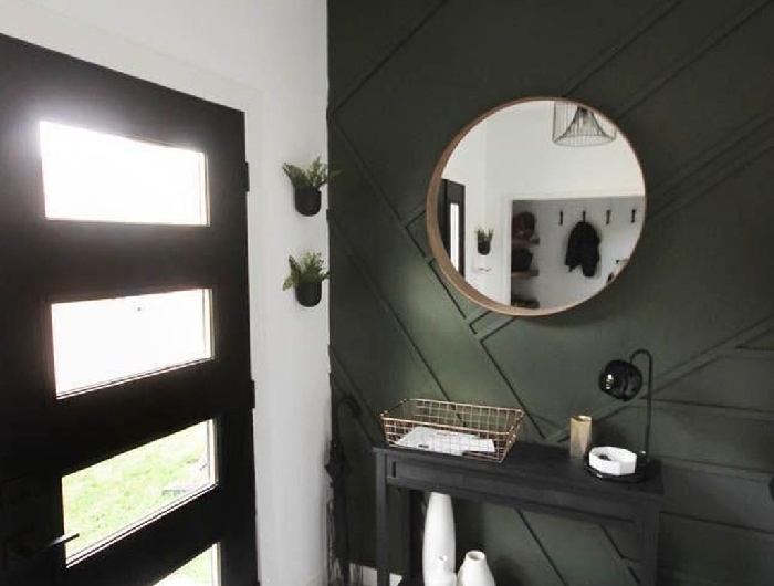 luminaire contemporaine métal noirci miroir rond cadre bois peindre couloir deux couleurs mur vert de gris meuble noir tabouret velours