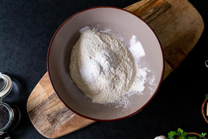 mélanger la farine blanche, le sucre glace et la levure dans un saladier assez large pour faire recette naan facile