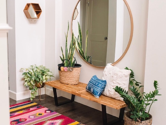 miroir rond cache pot paille pompons plantes vertes style boho éclectique tapis multicolore aménager une entrée avec banquette en bois