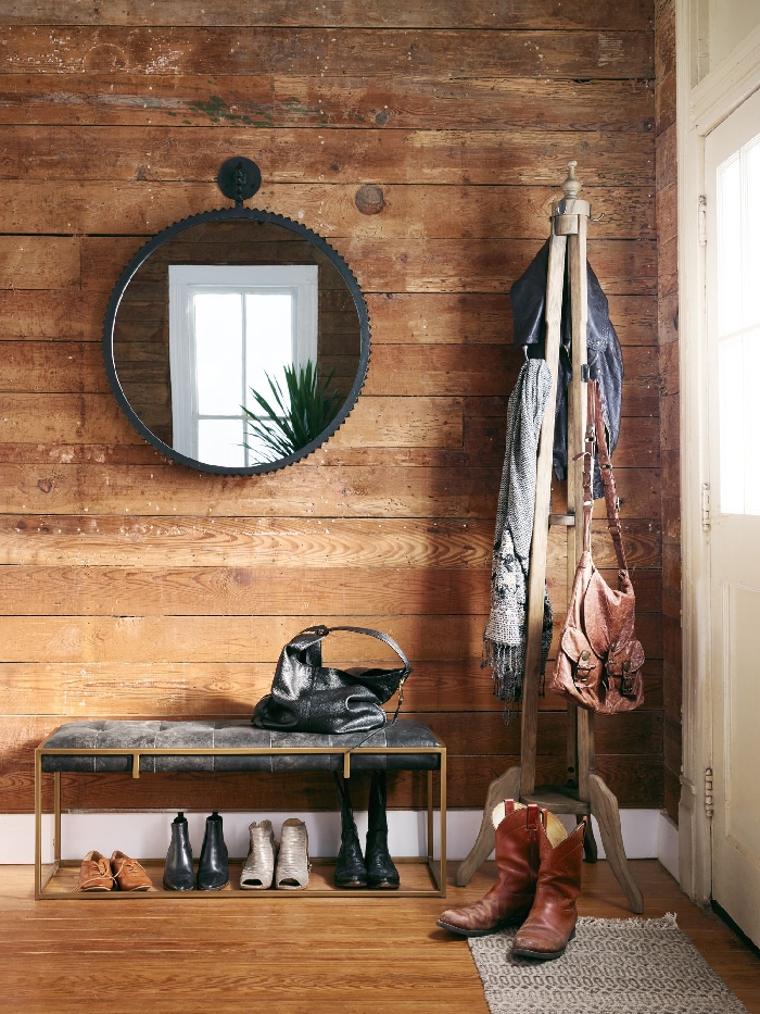 miroir rond cadre métal noirci banquette or et velours gris anthracite déco entrée maison style rustique revêtement mural bois foncé