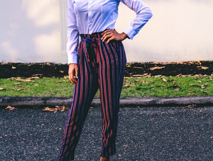 pantalon taille haute en rouge et bleu foncé chaussures à talons bleues coupe afro femme coiffure volume cheveux noirs chemise blanche femme