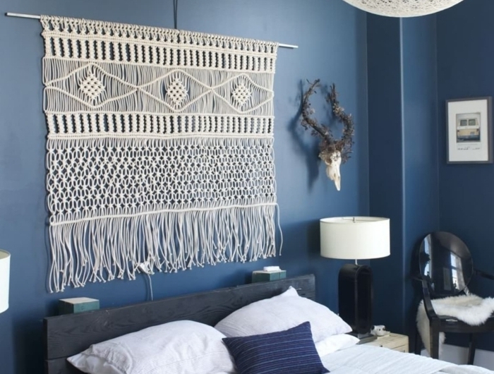 peinture murale bleue décoration chambre à coucher tête de lit macramé corde lampe de chevet blanc et noir chaise noire cornes décoratives