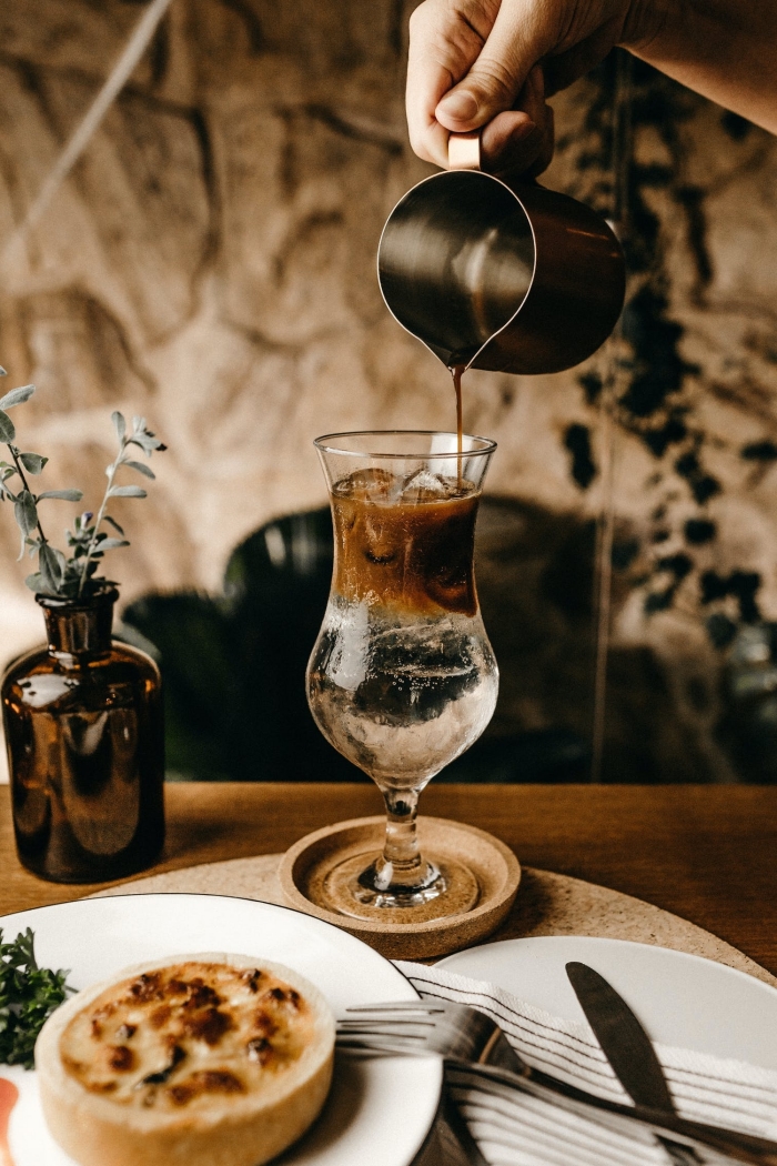 idée comment faire un café glacé nespresso facile, servir un café froid dans un verre à cocktail originale sur un sous-verre bois