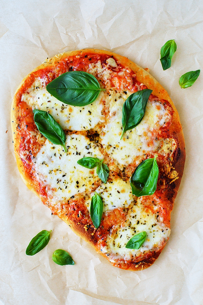 pizza sur pain naan à la mozzarella, tomates et des feuilles de basilic frais en top