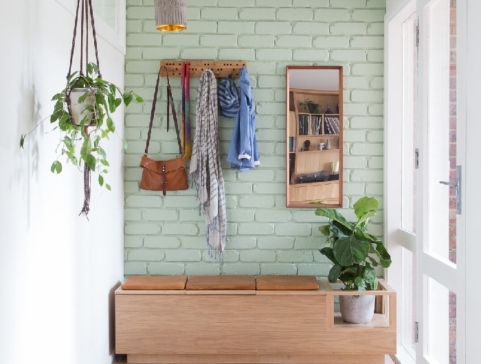quelle couleur pour agrandir un couloir mur briques vert pastel crochet rangement banquette bois siège cuir marron plante suspendue