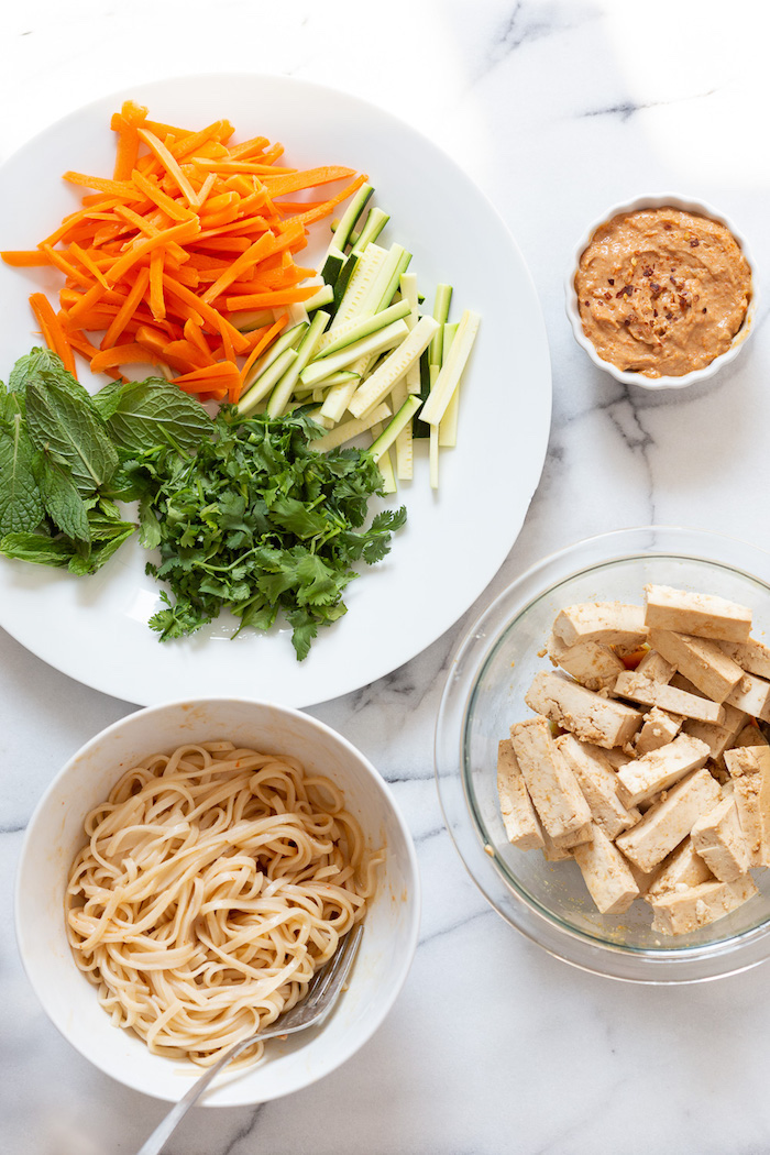 crudités, nouilles et tofu mariné pour faire un rouleau de printemps vegan, idée originale de repas à partager entre amis