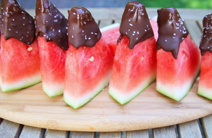 recette rapide dessert d été simple tranches de pastéque trempées dans du chocolat fondu glacé sucre plateau planche à découper bois