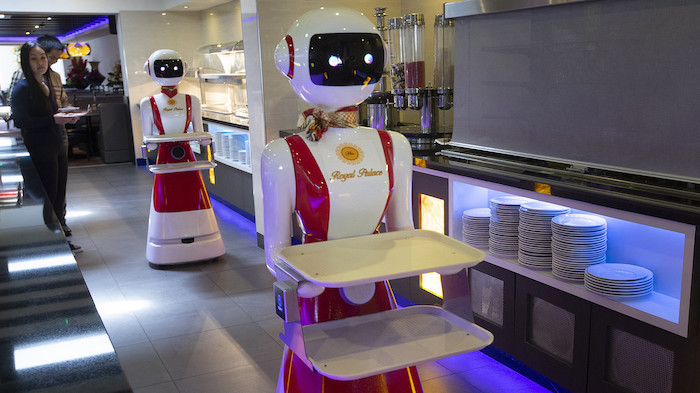 Robor en robe rouge et blanche, nouvel restaurant néerlandais remplace les serveurs avec des robots