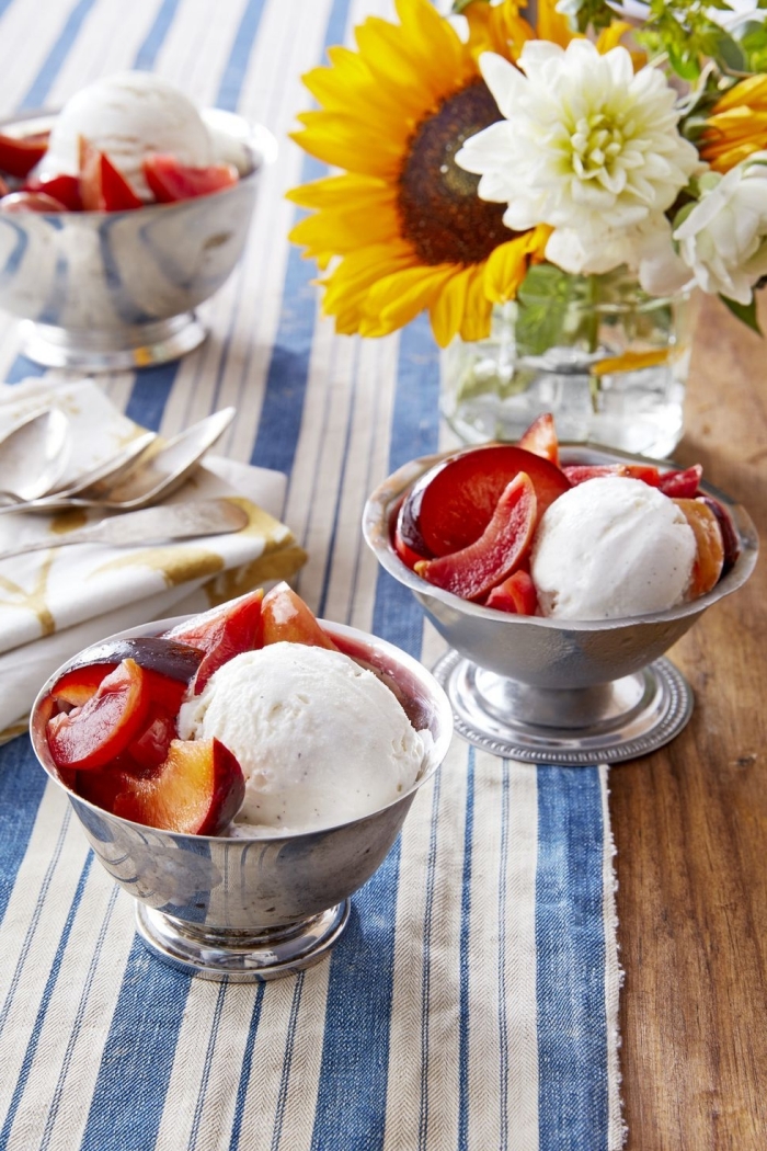 serviette blanc et bleu table bois recette dessert léger bouquet de fleurs tournesol bol crème glacée tranches de pêches et prunes dessert d'été