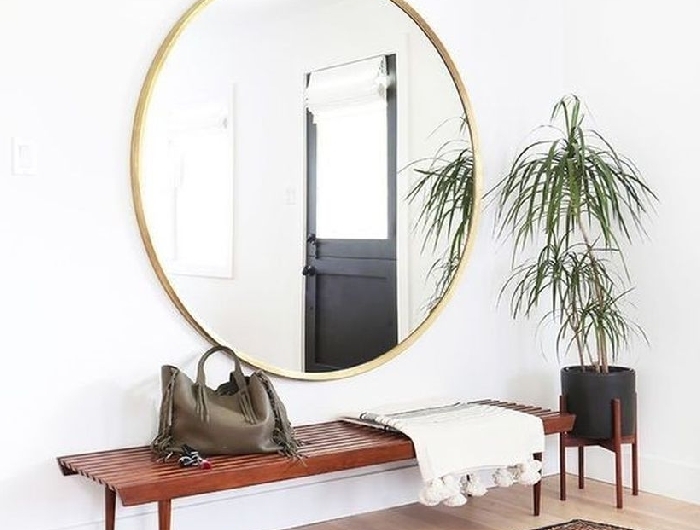 style bohème moderne palmier d intérieur banquette bois foncé décoration de couloir d entrée large miroir cadre or tapis marron