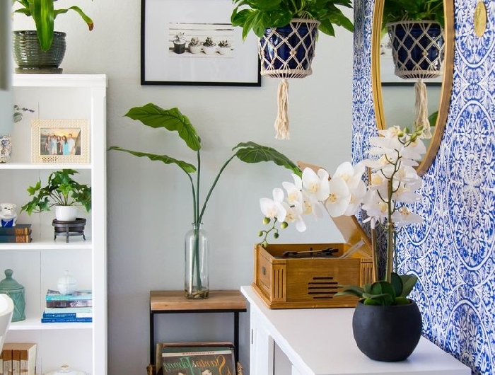 suspension plante macramé papier peint bleu et blanc meubles bois blanc tapis multicolore franges cadre photo noir peinture couloir