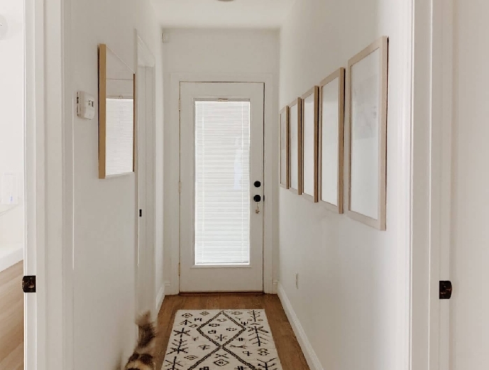 tapis blanc et noir motifs aménager une entrée étroite de style minimaliste cocooning cozy intérieur couloir mur de cadres bois