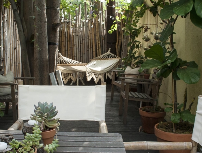aménagement cour arrière style boho chic hamac suspendu franges succulentes clôture palissade bambou intimité jardin meubles bois