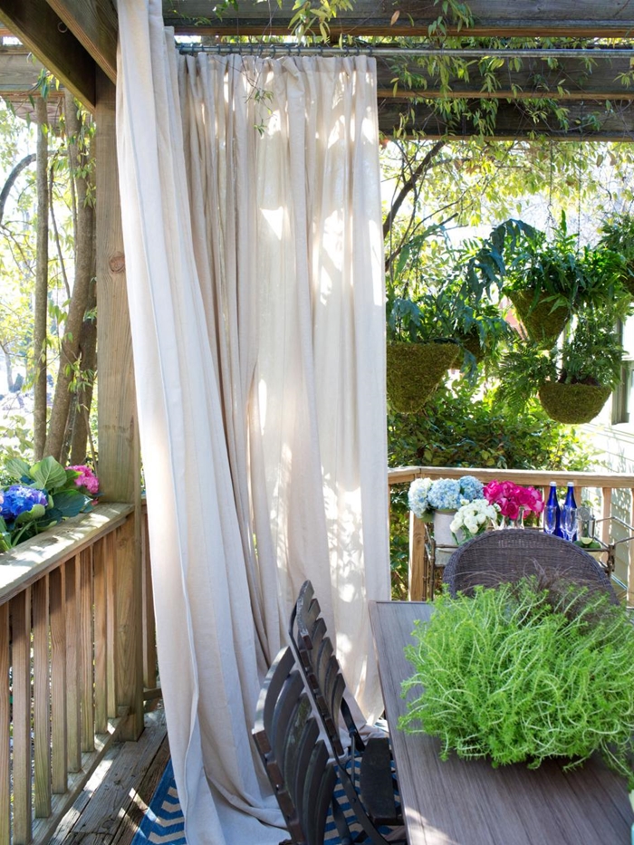 brise vue vegetal rideau blanc décoration véranda maison terrasse en bois pots de fleurs suspendus meuble extérieur bois foncé